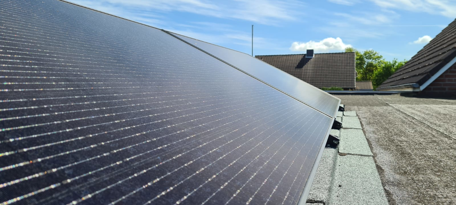 Zwei Full Black Solarmodule mit Schwarzen Triangelsystem Aufständerungen auf einem Flachdach.